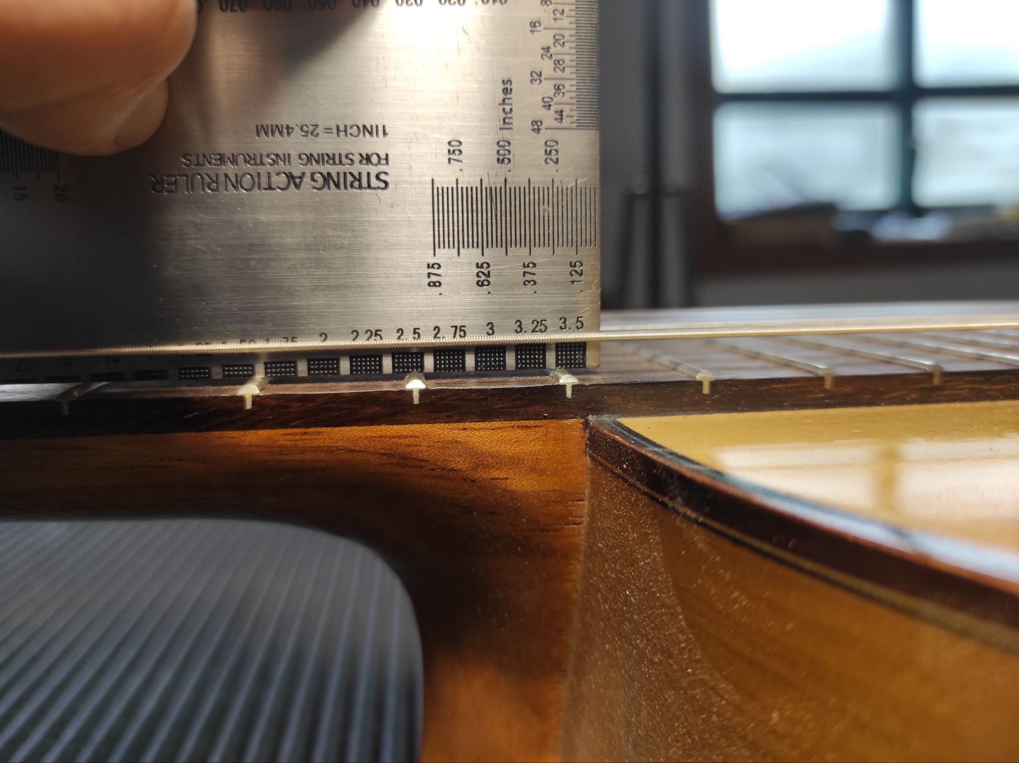 Luthier measuring guitar's action at 12th. fret