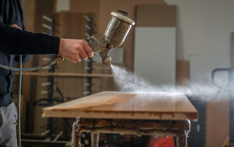 Spray gun over wood surface.